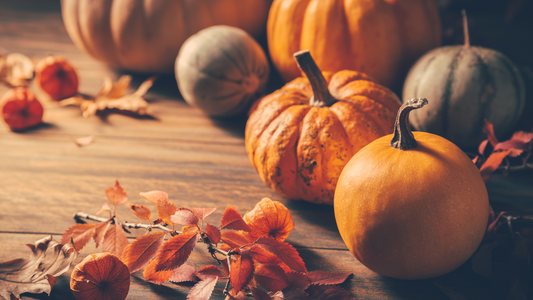 Pumpkins and leaves mix together into a fall background